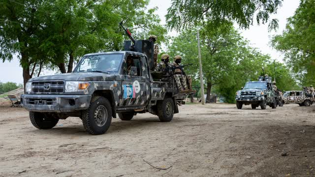 Military pickup trucks on a dirt road